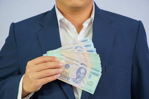 Money in Vietnam hold on hand business man wearing a blue suit (Socialist Republic Of Vietnam), Dong, VND, Pay, exchange money vietnamese on white background.