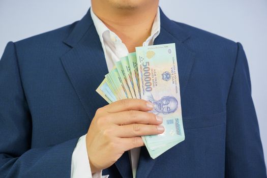 Money in Vietnam hold on hand business man wearing a blue suit (Socialist Republic Of Vietnam), Dong, VND, Pay, exchange money vietnamese on white background.