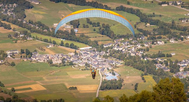 Saint Lary Soulan, France - August 20, 2018: paragliding in flight at the top of the mountain at 1700 meters above sea level flying over the valley on a summer day