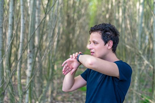 man speaks to smart watch when telephoning in nature.