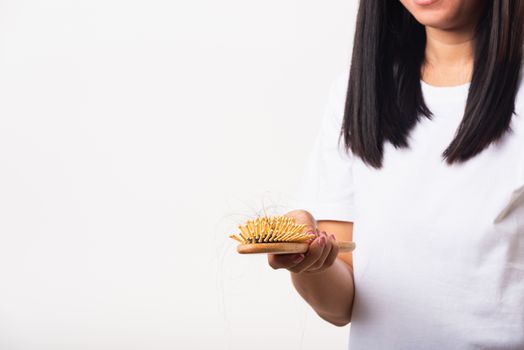 Asian woman unhappy weak hair she shows hairbrush with damaged long loss hair in the comb brush on hand, studio shot isolated on white background, medicine health care concept