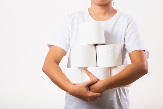Closeup Asian young woman stocking up toilet paper for home panic in stores quarantine from coronavirus. Female holding many rolls of toilet paper in arms on chest, studio isolated on white background