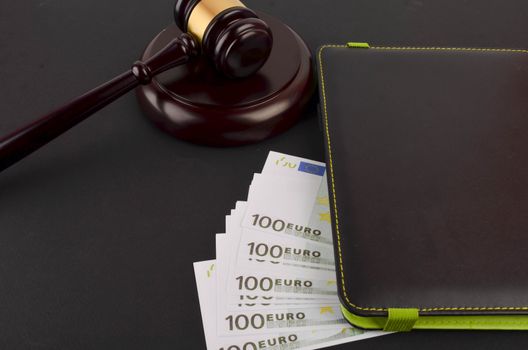 Gavel for judge lawyer with Euro banknotes on black background.