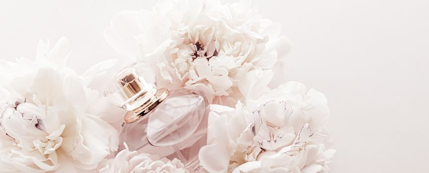 Fragrance bottle as luxury perfume product on background of peony flowers, parfum ad and beauty branding design