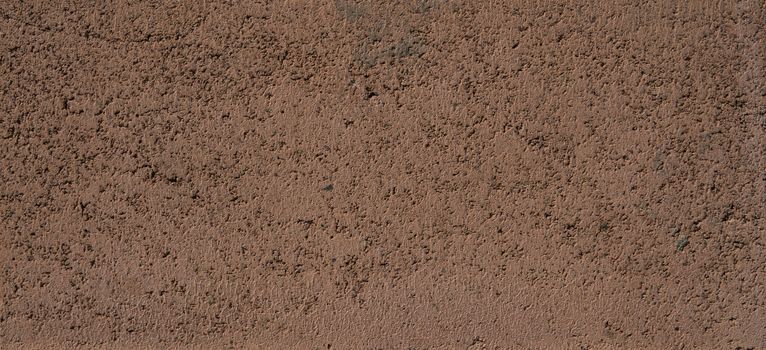 Brown-red walls stone texture lit by bright sunlight