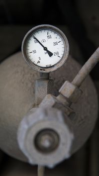 Industrial old white vintage barometer with old dirty gas cylinder