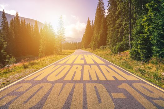 Driving on the road in the mountains to the New Normal (Normality) and leaving behind Covid-19 (Coronavirus). Covid-19 (Coronavirus) written on the asphalt road and New Normal or Normality concept. 