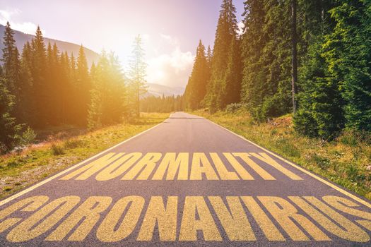 Driving on the road in the mountains to the New Normal (Normality) and leaving behind Covid-19 (Coronavirus). Covid-19 (Coronavirus) written on the asphalt road and New Normal or Normality concept. 