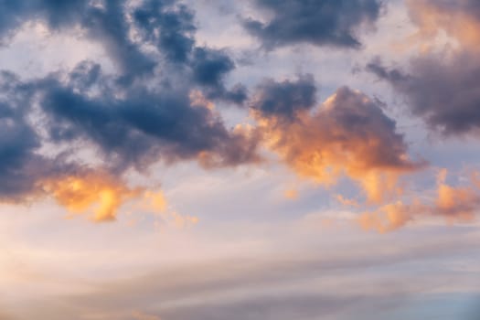 Beautiful sunset sky above clouds with dramatic light. Sunset sky for background, sunrise sky and clouds. Bright orange and blue sky and light of the sun. Beautiful sky with cloud before sunset.