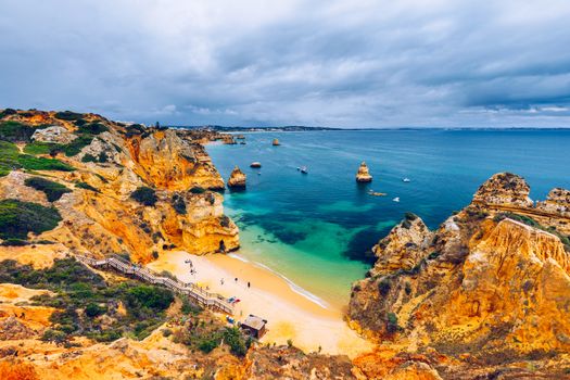 Camilo beach (Praia do Camilo) in Lagos, Algarve, Portugal. Wooden footbridge to the beach Praia do Camilo, Portugal. Picturesque view of Praia do Camilo beach in Lagos, Algarve region, Portugal.