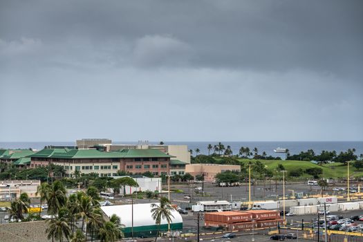 Honolulu  Oahu, Hawaii, USA. - January 11, 2020: Green roofed University of Hawaii Cancer Center and John. A. Burns School of Medicine with pier one contaiiner and infrastructure up front.