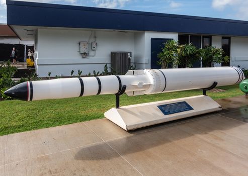 Oahu, Hawaii, USA. - January 10, 2020: Pearl Harbor. White Subroc anti submarine rocket goes from under water in the air and back under water. Green lawn, low building and people.