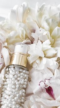 Luxurious cosmetic bottle as antiaging skincare product on background of flowers, blank label packaging for body care branding design