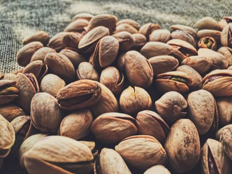 Pistachio nuts on rustic linen background, food and nutrition