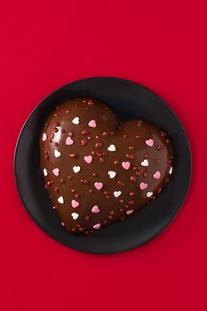 Heart shaped cake and red rose for Valentine's Day or mother's day on red background