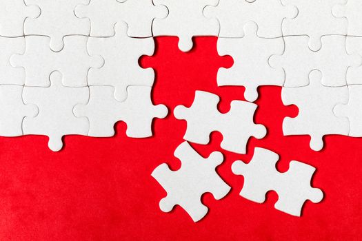 White jigsaw puzzle. White puzzle pieces on color background. Unfinished white jigsaw puzzle pieces on color background. 