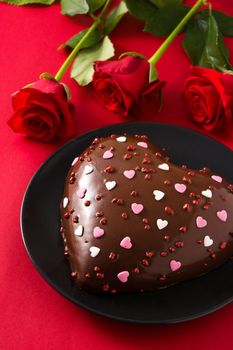 Heart shaped cake and red rose for Valentine's Day or mother's day on red background