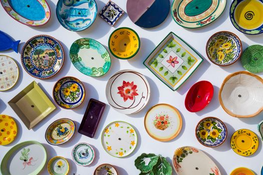 Collection of colorful Portuguese ceramic pottery, local craft products from Portugal. Ceramic plates display in Portugal. Colorful of vintage ceramic plates in Sagres, Portugal.