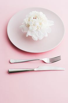 Dining plate and cutlery with peony flower as wedding decor set on pink background, top tableware for event decoration and dessert menu design