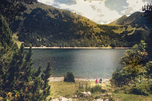 view of a couple watching the lake of Oule in the French Pyrenees