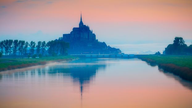 Beautiful panoramic view of famous Le Mont Saint-Michel tidal island at sunrise. Normandy, northern France