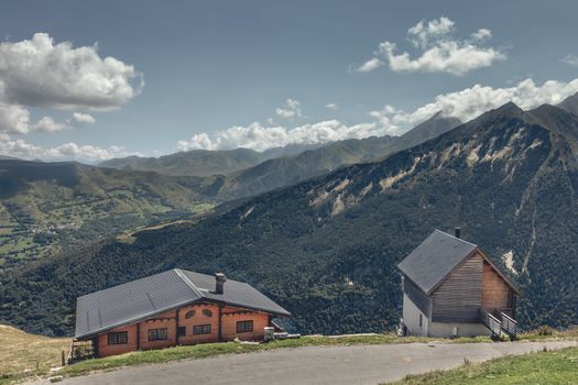 Saint Lary, France - August 20, 2018: Typical mountain log cabins on the height of the mountains with a plummeting view of the valley