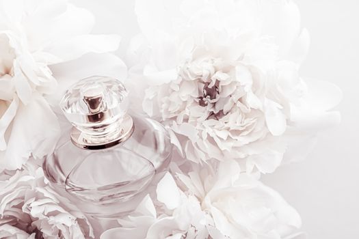 Chic fragrance bottle as luxe perfume product on background of peony flowers, parfum ad and beauty branding design