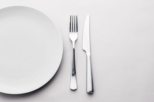 Empty plate and cutlery as mockup set on white background, top tableware for chef table decor and menu branding design