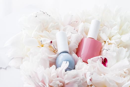 Nail polish bottles on floral background, french manicure and cosmetic branding design