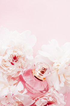 Luxe fragrance bottle as girly perfume product on background of peony flowers, parfum ad and beauty branding design