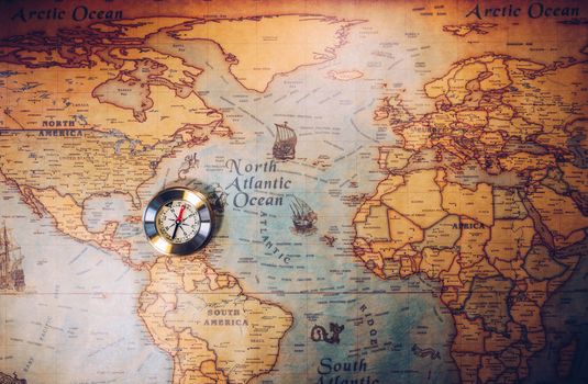 Old vintage retro golden compass on ancient map. Selective focus, shallow depth of field. Concept of world travel, sightseeing and tourism.