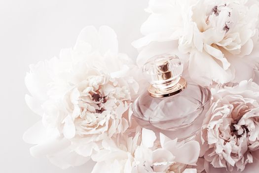 Fragrance bottle as luxury perfume product on background of peony flowers, parfum ad and beauty branding design