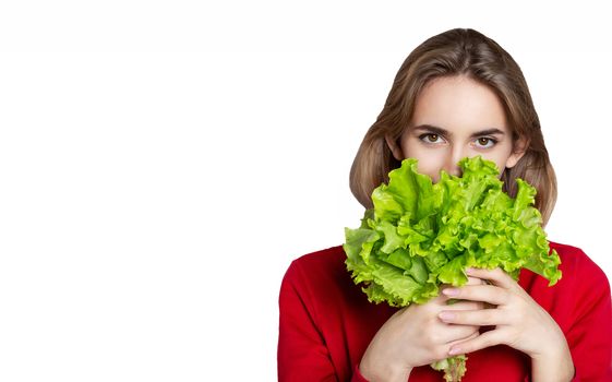 Lovely brunette woman wears red sweater holding lettuce isolated over a white background. Empty space