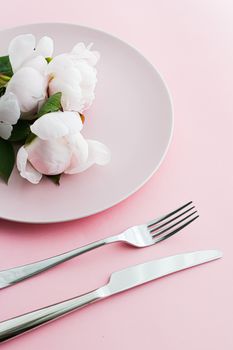 Dining plate and cutlery with peony flowers as wedding decor set on pink background, top tableware for event decoration and menu branding design