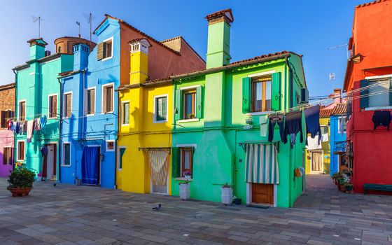 Street with colorful buildings in Burano island, Venice, Italy. Architecture and landmarks of Burano, Venice postcard. Scenic canal and colorful architecture in Burano island near Venice, Italy