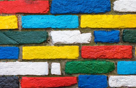 Burano, Venice, Italy. Brightly painted exterior brick wall in the colors of the rainbow. Burano village is famous for its colorful houses which are visible to the fishermen from the lagoon in mist. Venice, Italy.