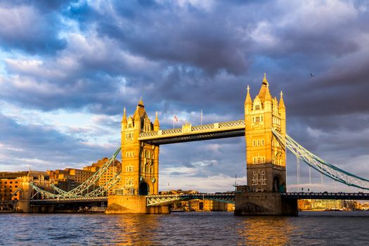 Tower Bridge with reflections at sunset in London, UK.