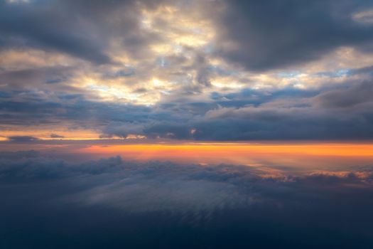 Beautiful sunset sky above clouds with dramatic light. Cabin view from airplane. Flying above the clouds. view from the airplane. Beautiful blue sky background with sunset. Sunset above the clouds.