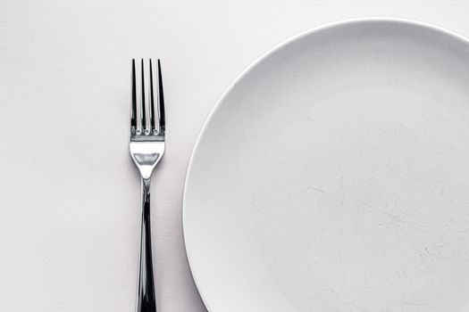 Empty plate and cutlery as mockup set on white background, top tableware for chef table decor and menu branding design