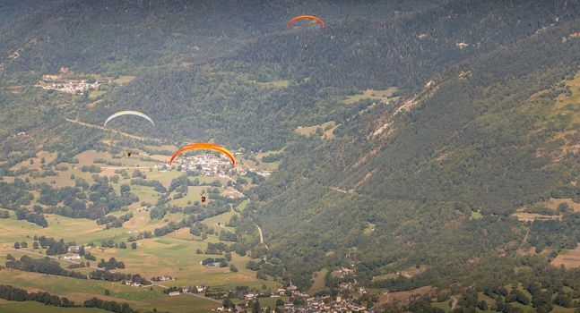 Saint Lary Soulan, France - August 20, 2018: several pair paragliders flying over the valley on a summer day
