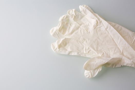 White medical gloves on a grey background. Empty space