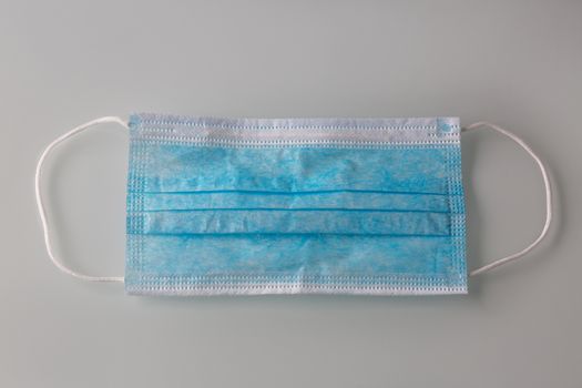 Surgical disposable mask for protection against Covid 19 against a grey background