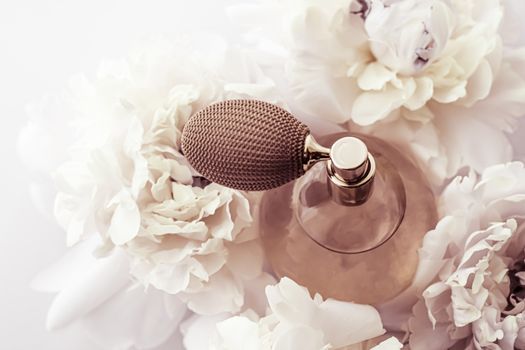 Retro fragrance bottle as luxury perfume product on background of peony flowers, parfum ad and beauty branding design