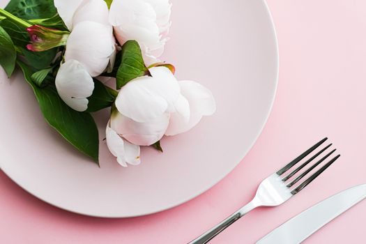 Dining plate and cutlery with peony flowers as wedding decor set on pink background, top tableware for event decoration and menu branding design