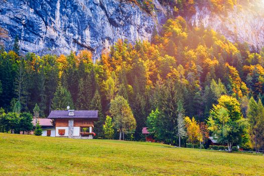 Autumn in the famous Dolomites mountains, Italy, Europe. Dramatic cliffs surround the village with the the iconic mountains and autumn forest. Colorful autumn landscape in mountain village. 