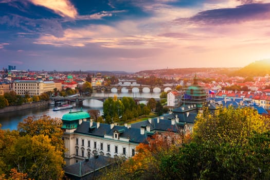 Autumn view to Charles bridge on Vltava river in Prague, Czech Republic. Autumn view to Charles Bridge, Prague old town and Vltava river from Letna park (Letenske sady) at sunset with colorful sky.