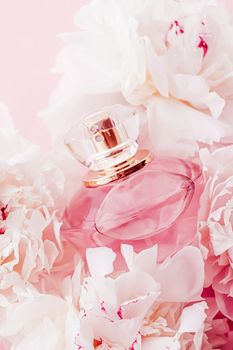 Luxe fragrance bottle as girly perfume product on background of peony flowers, parfum ad and beauty branding design