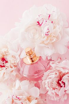 Luxe fragrance bottle as girly perfume product on background of peony flowers, parfum ad and beauty branding design