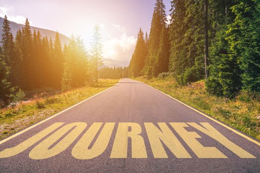 Journey word written on road in the mountains. Journey text on the road.