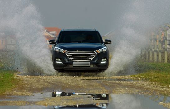 suv drives through flooded road